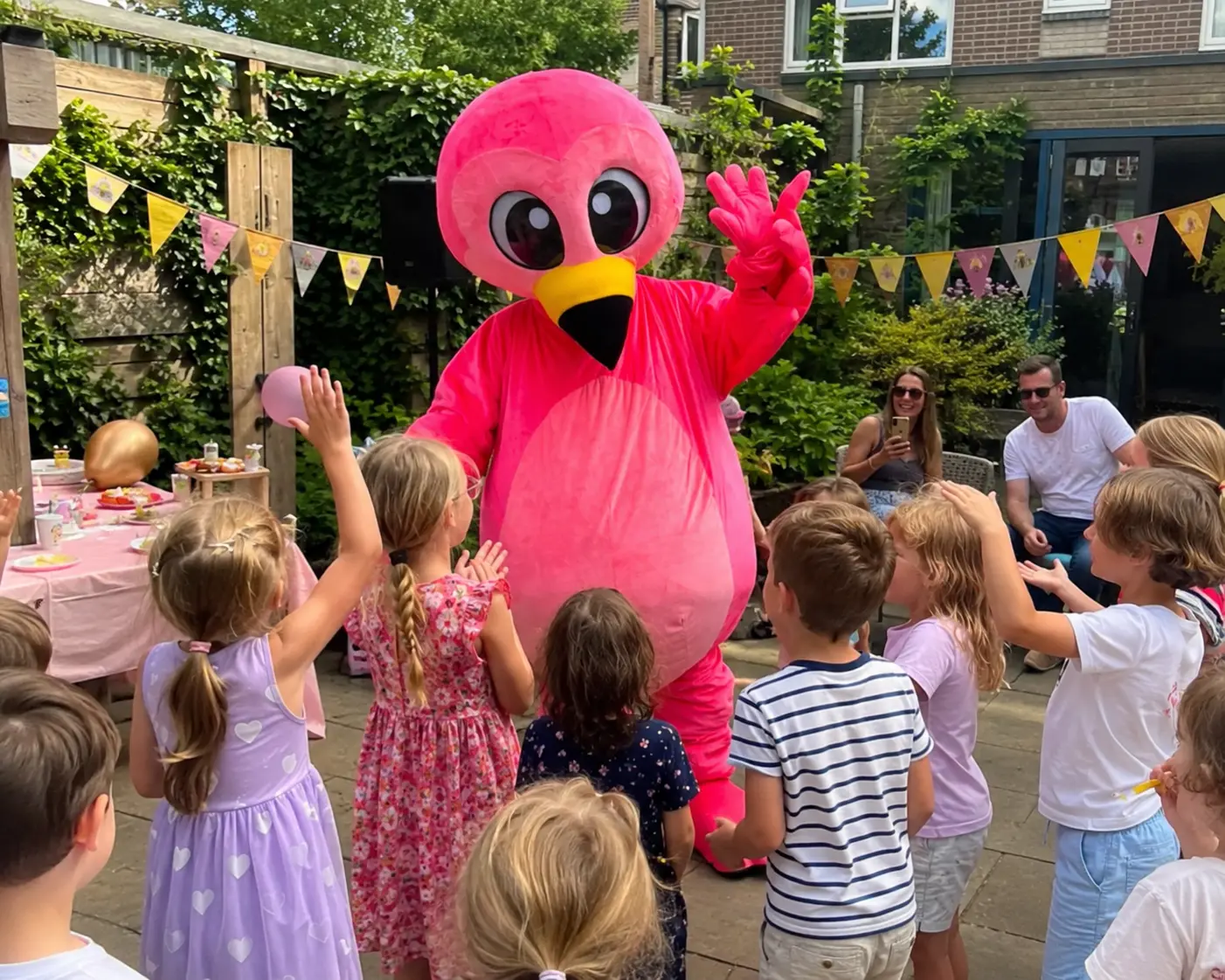 Flami speelt met een ballon tussen lachende kinderen op een tuinfeest